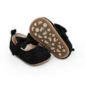 Primer plano de zapatos de princesa de encaje negro para bebé con lazo y suela de. - Negro