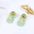 Close-up of green baby walker shoes with cute cartoon duck face and soft sole. - Fruit Green Duck