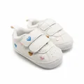 Close-up van witte baby-wandelschoenen met kleurrijk hartborduurwerk en klittenband - Kleurrijke Hartstijl (1511)