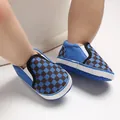 Close-up of blue checkered infant soft sole slip-on walking shoes. - Blue