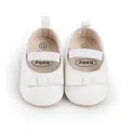 Draufsicht auf weiße Babyschuhe für Mädchen mit eleganten Schleifen und Gummibändern - Weiß