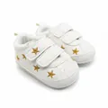 Detail van witte baby loopschoentjes met gouden sterren en klittenbandsluiting - Gouden Sterstijl (1512)