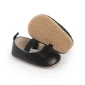 Detailansicht schwarzer Baby-Lauflernschuhe mit Schleife und rutschfester Gummisohle - Innenlänge 13cm / Schwarz