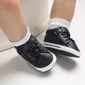 Dettaglio di scarpe da bambino blu scuro in ecopelle con suole bianche morbide per primi passi. - Blu