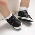 Dettaglio di scarpine primi passi alte in finta pelle nera con suole morbide per neonati - Nero
