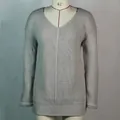 Detail of grey V-neck knitted sweater dress showing vertical ribbed texture and loose fit - Light Gray