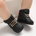 Close-up of black high-top baby shoes with soft soles and plaid accents. - Black