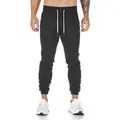 Close-up of men's black slim-fit cotton joggers for gym training and running - Black