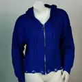 Nahaufnahme eines blauen Kapuzenstrickpullovers mit asymmetrischem Fransen Saum - Saphirblau
