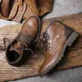 Gros plan détaillé de bottes de travail en cuir marron rétro sur bois rustique. - Brun Rétro