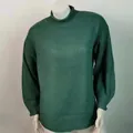 Primer plano de un jersey de punto oversize verde oscuro con cuello alto - Verde Oscuro
