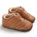 Close-up of brown baby walker shoes with decorative brogue perforations and Velcro strap - Brown