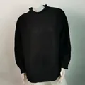 Elegante jersey de punto negro con cuello alto y trama estructurada en maniquí - Negro