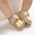 Nahaufnahme goldener Babyschuhe mit niedlichem Löwen-Design und Klettverschluss - Gold