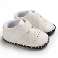 Detail view of stylish white baby walking shoes with textured faux leather and velcro straps - White