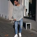 Lässiger grauer Herrenstrickpullover kombiniert mit Distressed-Jeans in Straßenszene - Grau