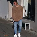 Nahaufnahme eines männlichen Models in einem braunen langärmligen Strickpullover. - Khaki
