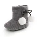 Vue détaillée de bottes tricotées pour bébé grises avec pompons blancs et nœud - Gris