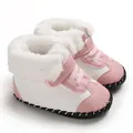Close-up view of pink and white baby snow boots featuring fluffy faux fur lining and soft soles - Pink