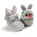 Detailopname van pluche konijnen babyschoentjes met zacht kunstbont en een grijs strikje. - Grijs