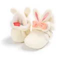 Detail van pluche baby-schoentjes met roze konijnenoren en een strikje - Wit