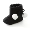 Gros plan de bottes d'hiver noires pour bébé avec pompons blancs et maille douce - Noir