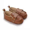 Close-up showing the pebble grain texture of brown soft-sole baby loafers with gold buckle. - Dark Brown