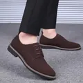 Gros plan sur des chaussures derby en daim marron pour hommes avec pantalon noir - Brun Foncé