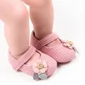 Soft pink knitted baby girl princess shoes featuring decorative flower and wooden button. - Pink