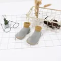 Detailaufnahme der rutschfesten Babysocken mit weicher Sohle aus grauem und gelbem Strick - Grau