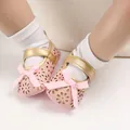 Detailansicht der rosa Baby-Prinzessin-Schuhe mit Blumenmustern und Schleifenverzierung - Rosa