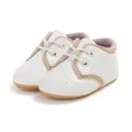 Detailed view of white soft-soled baby walking shoes featuring classic lace-up design - 13cm (12-18 Months) / Milky White