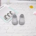 Vista superior de zapatos de punto para bebé a rayas grises y blancas sobre ladrillo - Talla 18/19 (Longitud interna 11,5 cm) / Estilo de Rayas / Gris