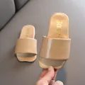 Cómodas chanclas beige para niños con elegante texto coreano dorado en la plantilla. - Caqui