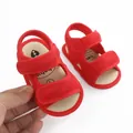 Macro view of red mesh baby sandals showing the soft texture and velcro straps. - Red