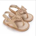 Close-up of gold glitter baby walking sandals with butterfly applique and soft soles - Gold