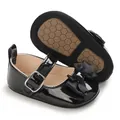 Detailed view of black patent leather infant walking shoes with bow and anti-slip honeycomb sole - Insole Length 11cm / Black
