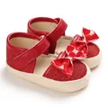 Close-up of red glittery baby princess shoes with patent leather bow detail. - Inner Length 11cm / Red