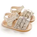 Detail von goldglitzernden Babysandalen mit Rüschendesign und verstellbarem Riemen - Gold