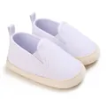 Macro view of white canvas baby slip-on shoes with braided sole detailing. - White