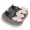 Close-up detail of soft sole non-slip baby girl walker shoes with pink butterfly bow - Gray