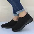 Detailopname van zwarte ademende gebreide instapsneakers voor dames op de voet getoond - Zwart