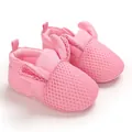 Dettaglio di scarpe da neonato in rete rosa con graziose orecchie da coniglio e suola morbida. - Rosa