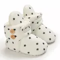 Detalle de botas de nieve blancas para bebé con estrellas negras y suave forro de felpa - Blanco