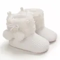 Detailed view of white baby princess boots with soft fur and decorative pom-poms - White