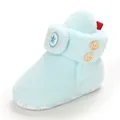 Dettaglio di scarponcini per neonati in peluche azzurro con logo a stella e bottoni in legno - Azzurro