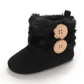Close-up detail of black infant snow boot featuring faux fur trim and wooden buttons - Black