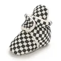 Detailed view of baby checkerboard boots with warm fleece lining and soft non-slip soles. - Black