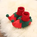 Detail view of cute red and green Christmas elf baby booties on a soft white faux fur rug. - Inner Length 11cm / Elf Red Green Patchwork (D28)