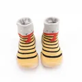 Front view of striped baby sock shoes featuring thick tan rubber soles for first walkers - Turmeric Striped Bear